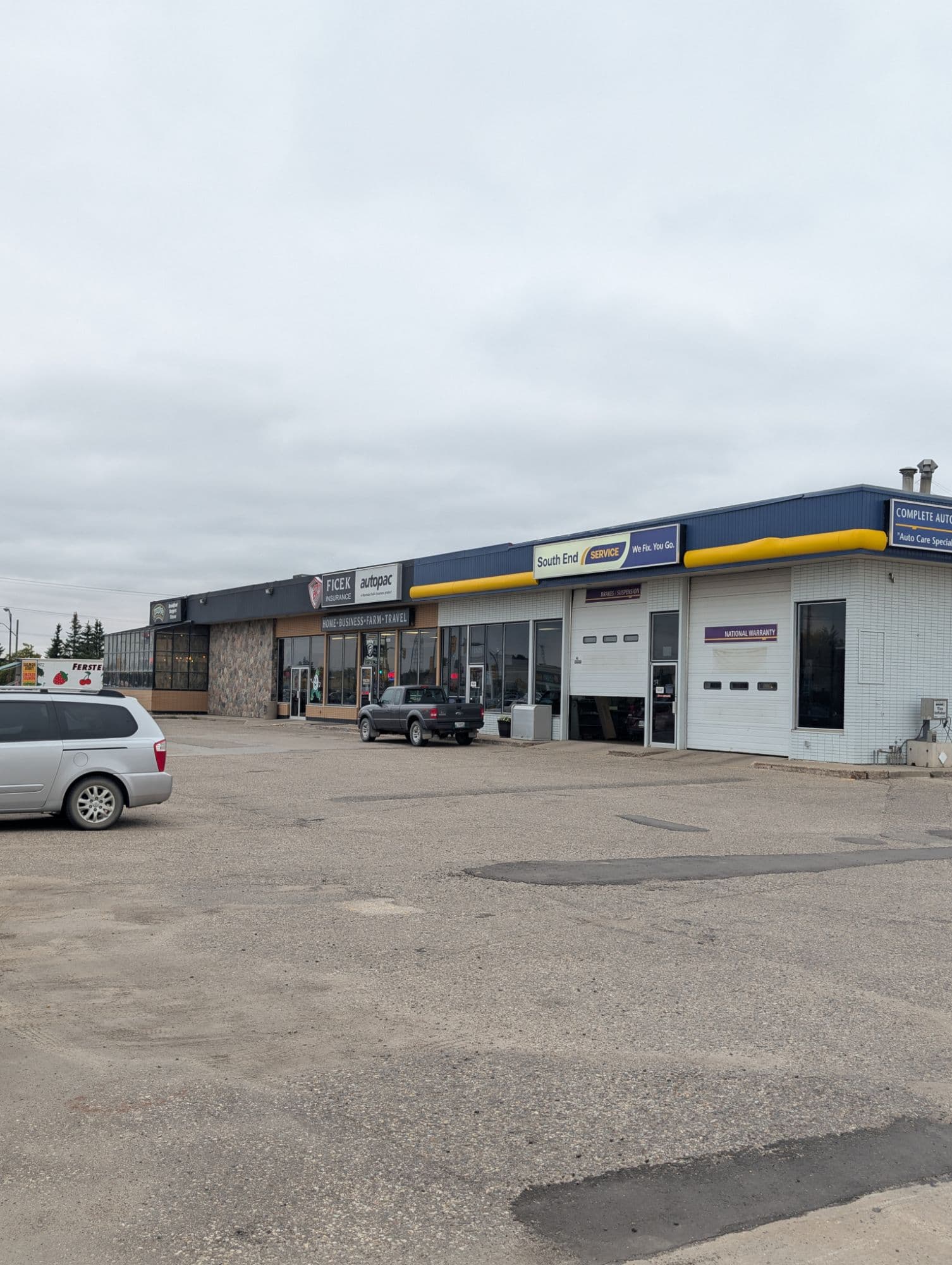 The parking lot in front of the 1525B 18th Street office, with open stalls directly outside the Ficek Insurance entrance and South End Service next door.